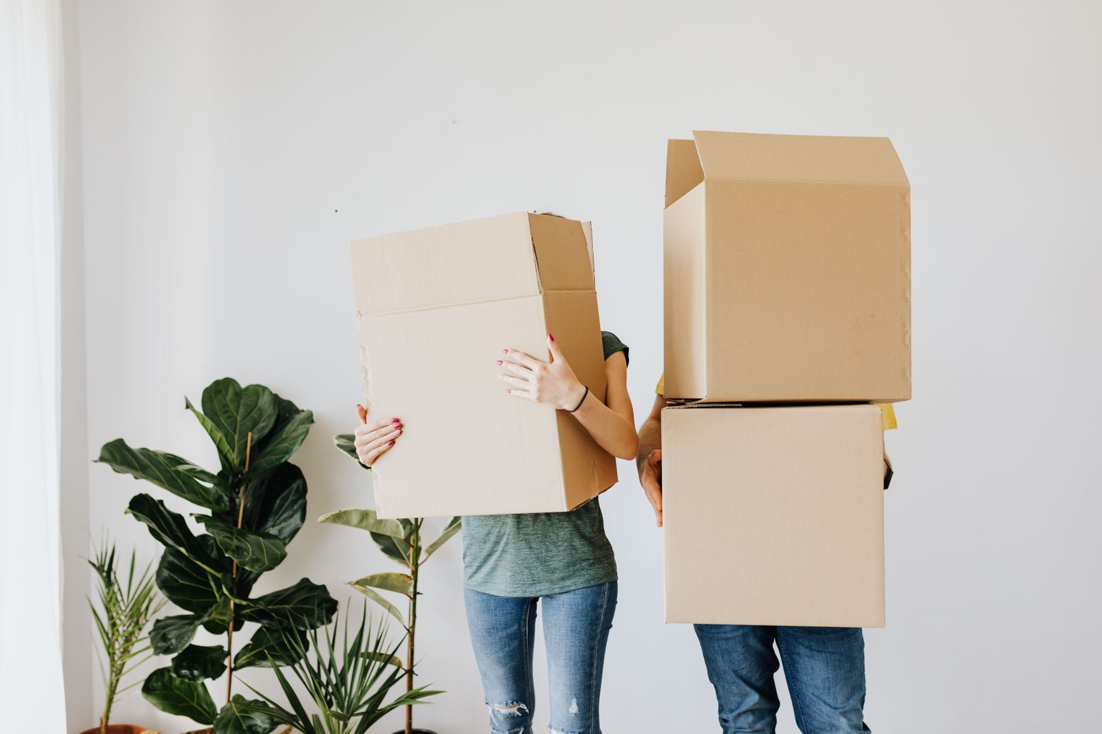 Couple carrying moving boxes into a new rental